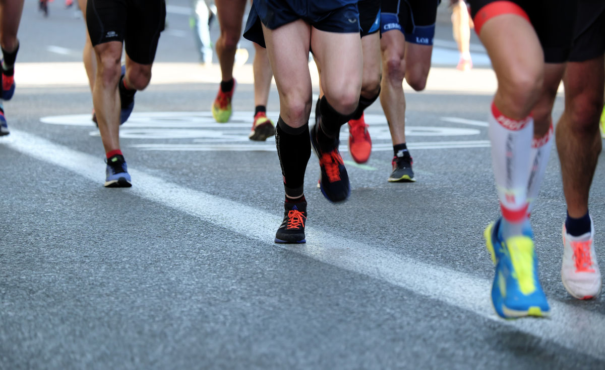 Jambes de coureurs sur la route pendant une course à pied populaire