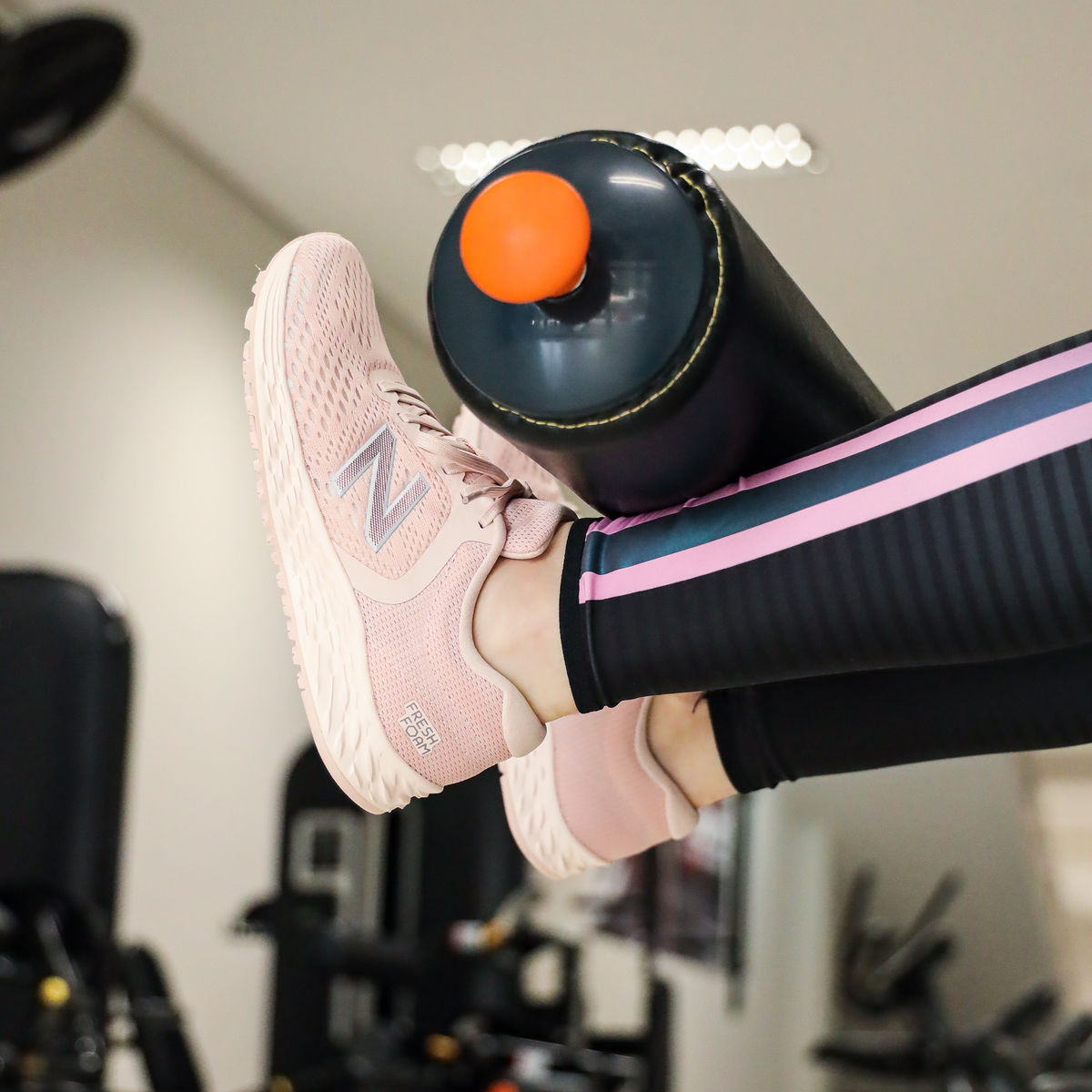 Jambes posées sur un rouleau de massage en salle de sport
